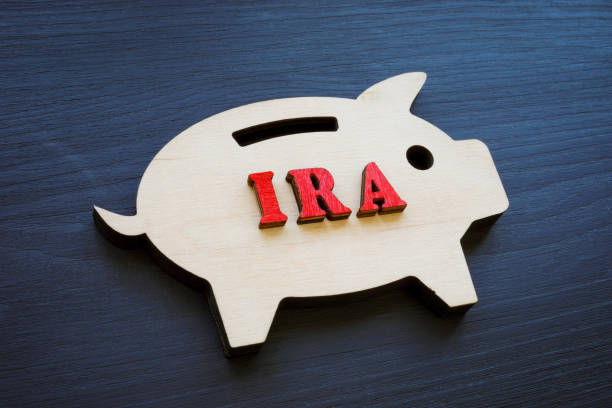 Wooden piggy bank and IRA individual retirement account abbreviation. stock photo