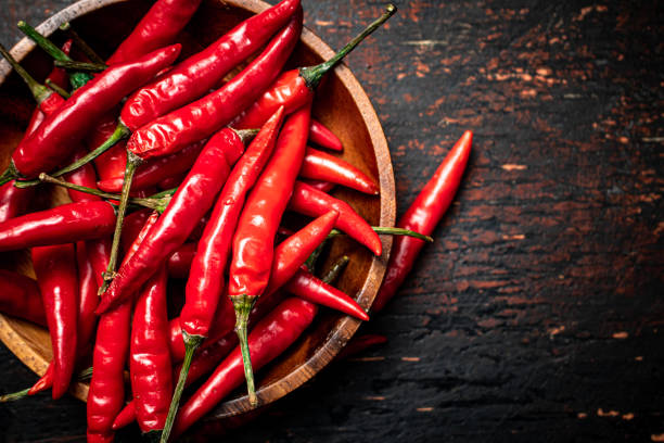 Wooden plate with hot chili peppers. stock photo