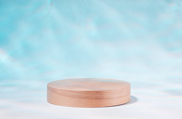 Wooden podium or product stand by swimming pool with reflection of sunlight from water stock photo