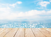 Wooden table top on blue sea and white sand beach background