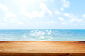 Hölzerne Tischplatte auf verschwommenem Sommer blaues Meer und Himmel Hintergrund. Kopieren Sie Speicherplatz für Ihr Display- oder Montageproduktdesign.