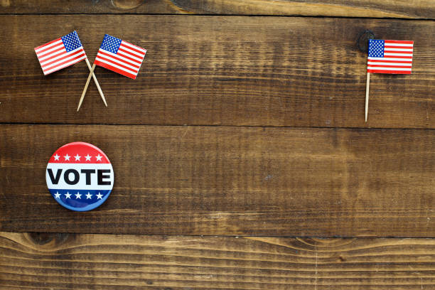 Wooden table top with vote sign and little american flags stock photo
