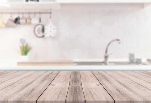 Wooden table with kitchen on the blurred background - modern bright dining room Wooden table with kitchen on the blurred background - modern bright dining room kitchen counter stock pictures, royalty-free photos & images