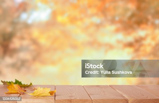 istock Wooden tabletop in the nature blurred background 1334125357