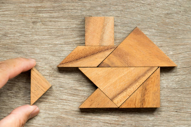 rompecabezas de tangram de madera en espera de hogar forma de terminación (concepto de vida familiar de edificio o sueño) - tangram casa fotografías e imágenes de stock