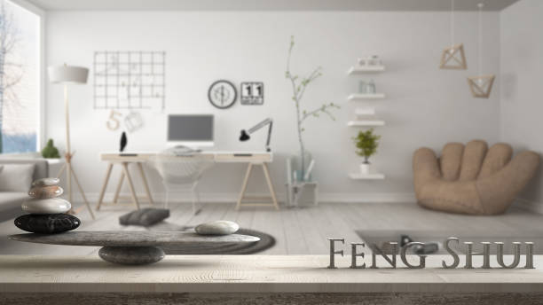 Wooden vintage table shelf with stone balance and 3d letters making the word feng shui over modern home corner office, zen concept interior design stock photo