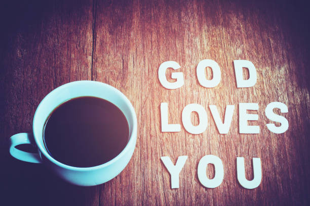 Word " God loves you " with a cup of coffee on wooden background, Christian concept stock photo