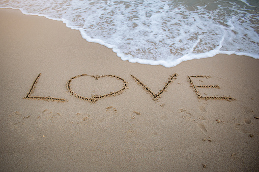 Word love written on the beach. Word love on the beach. signs on the beach sand