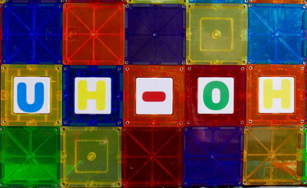 Word "uh-oh" spelled out in colorful magnetic tile toys stock photo