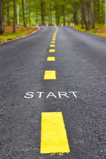 Words of start with yellow line marking on road surface stock photo