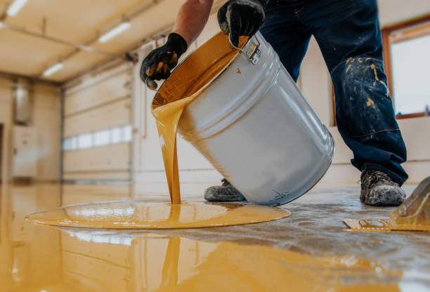 trabajador aplicando un cubo de resina epoxi amarillo en el suelo para la capa final. - suelo fotografías e imágenes de stock