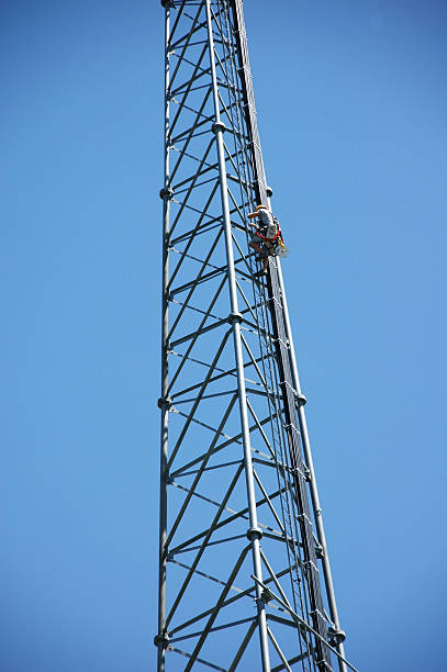 Worker climbing a cell tower stock photo