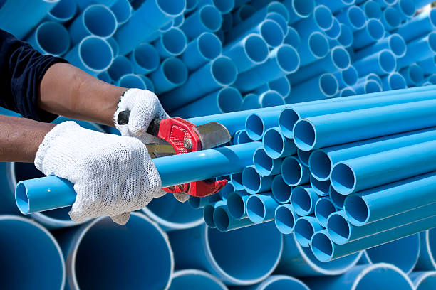 Worker cut pvc pipe in construction site Worker cuting blue pvc pipe in construction site. pvc stock pictures, royalty-free photos & images