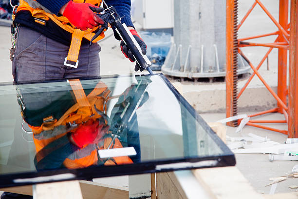 Worker cutting glass in a factory warehouse stock photo
