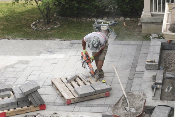 Worker cutting pavers to interlock driveway stock photo