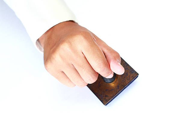 Worker hand holding rubber stamp stock photo