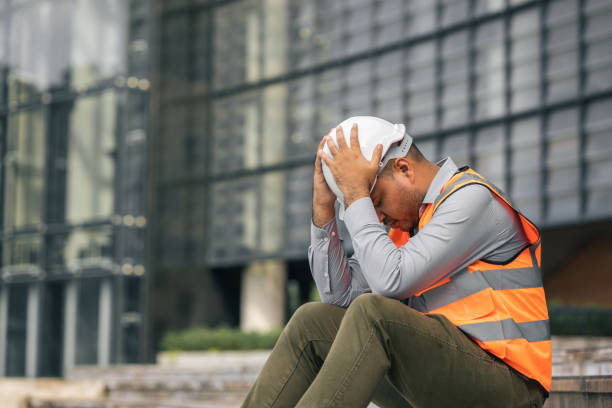 Worker hard working at construction site he tired and disconsolate. The civil engineer made a mistake, he was very stressed. Damage the structure of the building causing a breakdown. stock photo