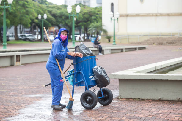 Worker in coronavirus pandemic Public cleaning worker in Apucarana, southern Brazil, with protective mask is photographed in the square during a coronavirus pandemic public service stock pictures, royalty-free photos & images