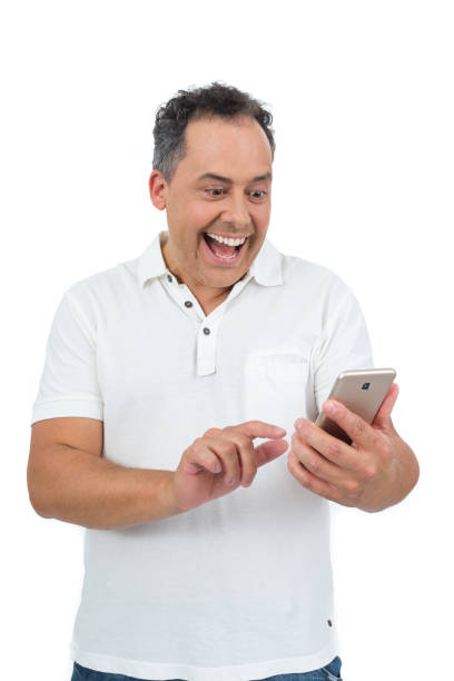 Worker is having fun with his cell phone. He is overweight and is wearing a white polo."n Man with overweight is wearing white polo. Isolated on white background. He gets good news and information on his cell phone. Surprised and excited. fat man looks at the phone stock pictures, royalty-free photos & images