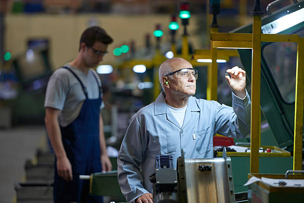 Worker looking at product in bolt factory stock photo