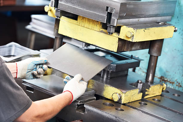 worker operating metal sheet press machine stock photo