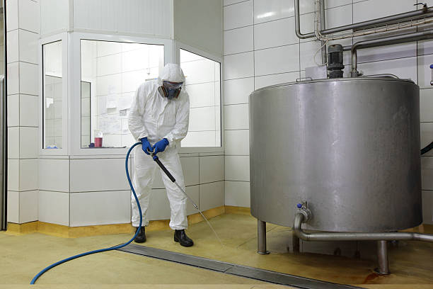 worker  with high pressure washer, cleaning floor in plant stock photo