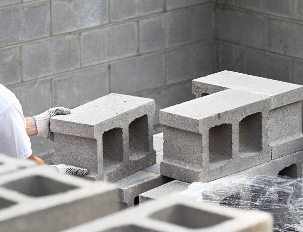 Worker With Safety Gloves Stacking Concrete Blocks stock photo