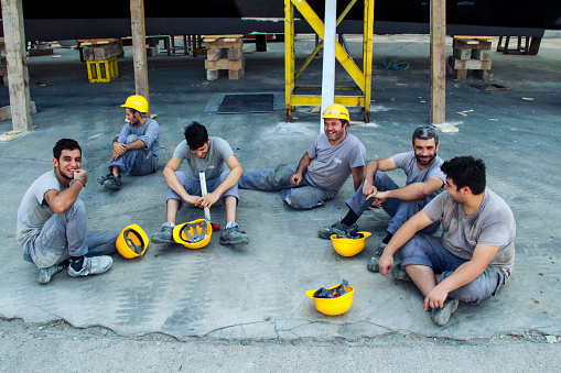 Antalya, Turkey - 08/18/2017: Shipyard workers sitting tired during lunch break