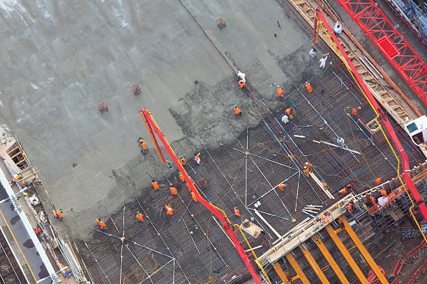 workers laying concrete - aerial view stock photo