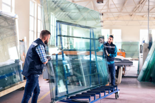 Workers packaging glass sheets in warehouse stock photo