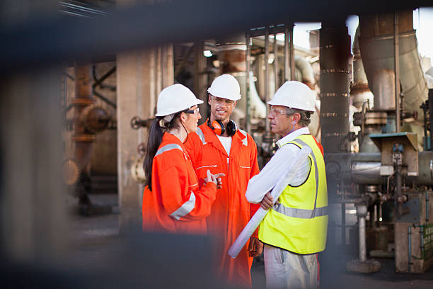 Workers talking at oil refinery  oil refinery stock pictures, royalty-free photos & images
