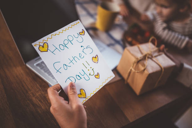 Working at home father holding father's day card and gift Close-up of father's hands holding handmade card and present from children on father's day wundervisuals stock pictures, royalty-free photos & images