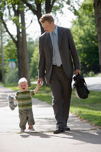 Working Dad walking with his son stock photo