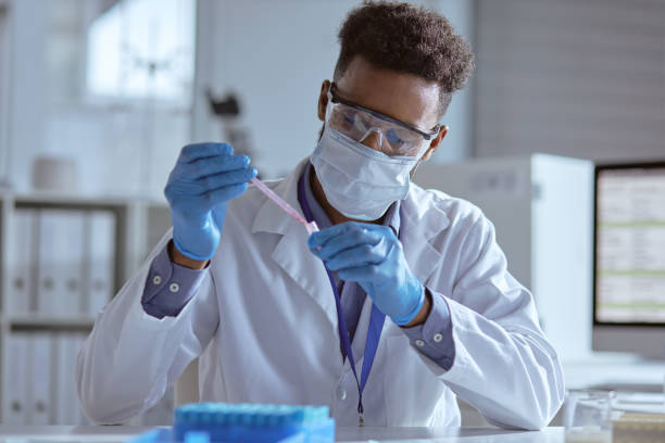 Working in the pathology centre Shot of a young scientist working with samples in a lab pipette stock pictures, royalty-free photos & images
