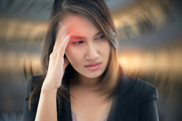 Working woman has Headache Against gray background, Benign Paroxysmal Positional Vertigo: BPPV, Concept with Sickness and Healthcare. stock photo