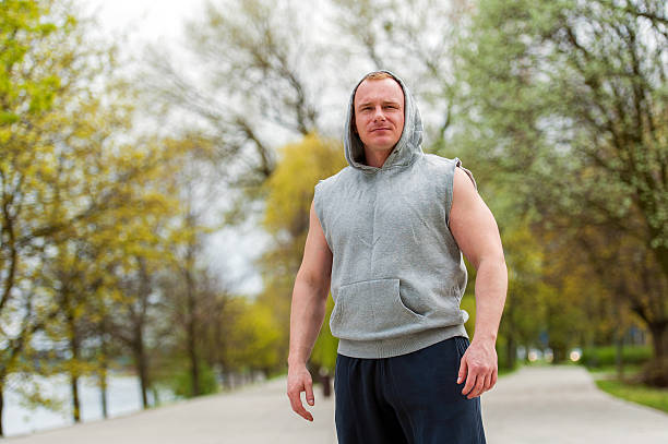 Workout man in hood resting. Outdoor. stock photo