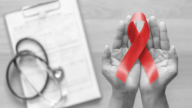 World aids day and national HIV/AIDS and ageing awareness month with red ribbon on woman hand support (bow isolated with clipping path)  world aids day stock pictures, royalty-free photos & images