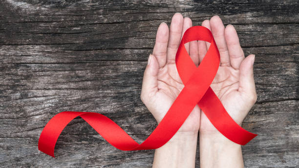 día mundial de las ayudas y mes nacional de concienciación sobre el vih/sida y el envejecimiento con cinta roja sobre el apoyo de la mano de la mujer (lazo aislado con camino de recorte) - world aids day fotografías e imágenes de stock