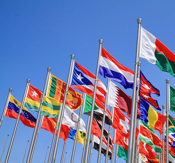 World flags on poles waving in the sky stock photo