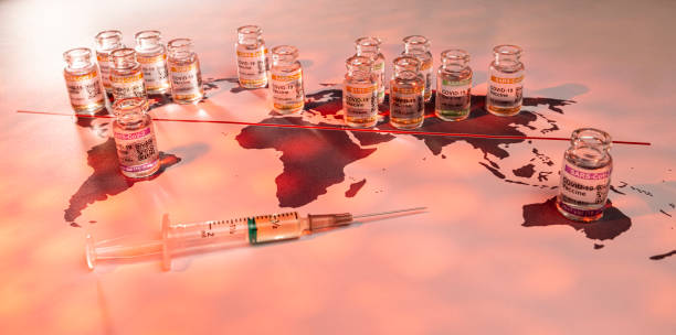 World globe map with vials for the global SARS/COVID pandemic vaccine war, with vaccine hoarding, restricting equal access to vaccines across the world, seen as a moral failure resulting in inequality stock photo