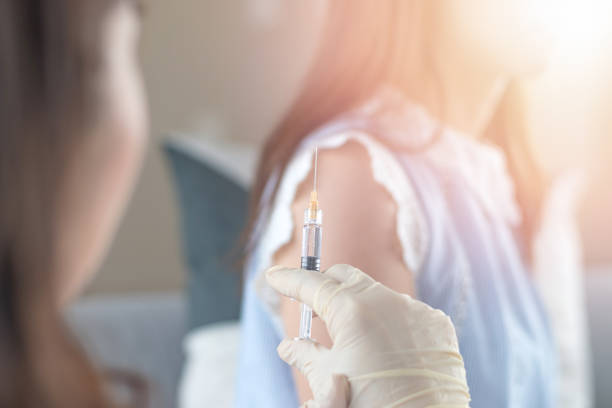 world immunization week and international hpv awareness day concept. woman having vaccination for influenza or flu shot or hpv prevention with syringe by nurse or medical officer. - world cancer day imagens e fotografias de stock