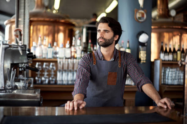 World’s best barkeep Shot of a young man working behind the counter of a bar Waiting or Bartending stock pictures, royalty-free photos & images