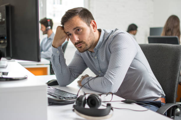 Worried beard man looking at computer screen in office stock photo