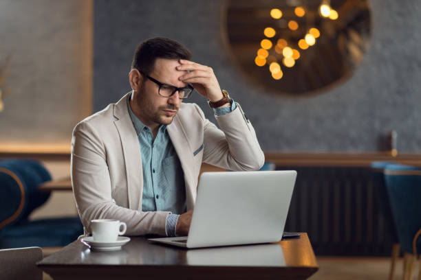 Worried businessman using laptop in a cafe stock photo