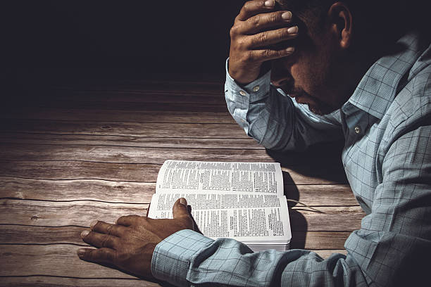 Worried man reading the Holy Bible stock photo