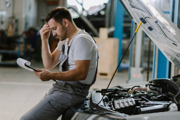 Worried mechanic having problems whit checklist in a workshop stock photo