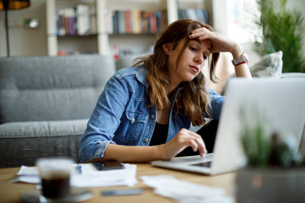 Worried young woman working at home stock photo