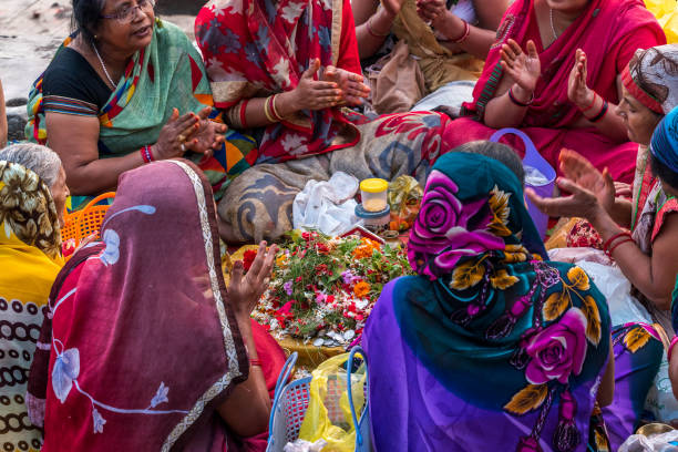 Worship October 14,2017. Varanasi,India. Hindu women chanting and counting mantras for offering in the Ganges river at Varanasi ghat. Selective focus is used. chhath stock pictures, royalty-free photos & images