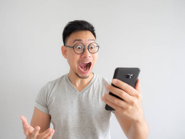 Wow face of man shocked what he see in the smartphone. stock photo