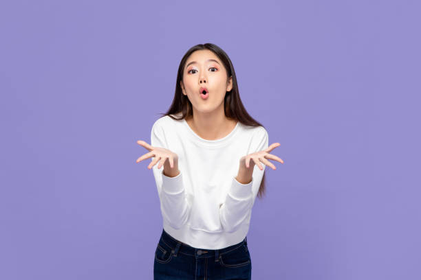 Wow surprised young Asian girl with both hands open Wow surprised young Asian girl with both hands open isolated on purple background cute thai girl stock pictures, royalty-free photos & images